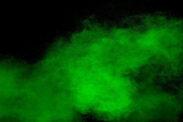 Esplosione di polvere verde astratta su sfondo nero bloccare il movimento della nuvola di polvere verde