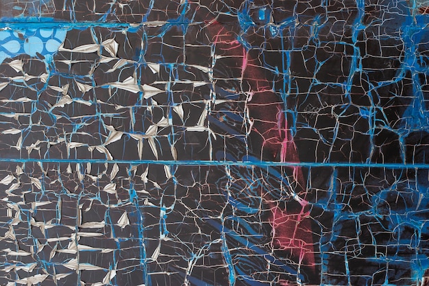 Abstract grunge background. Texture of torn old torn paper on the wall. Blue, red, black color.