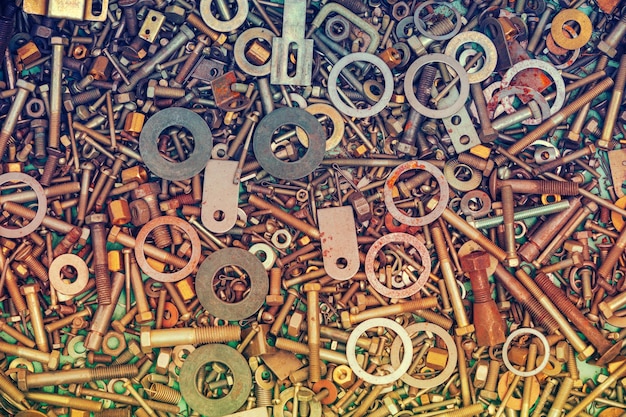 Abstract grunge colorful metal background made of fastening bolts screws nuts