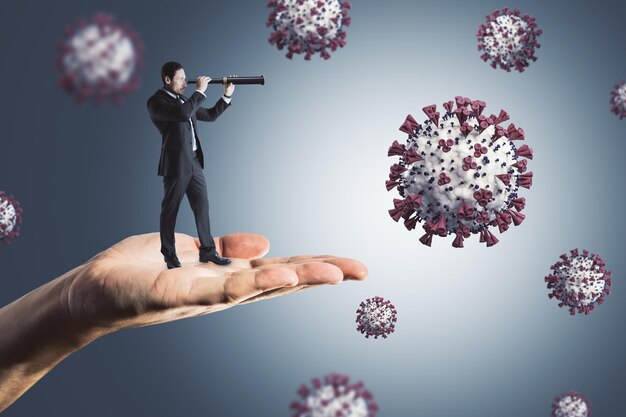 Abstract hand holding businessman looking into the distant future on gray background with virus Pandemic epidemic coronavirus health and medicine concept