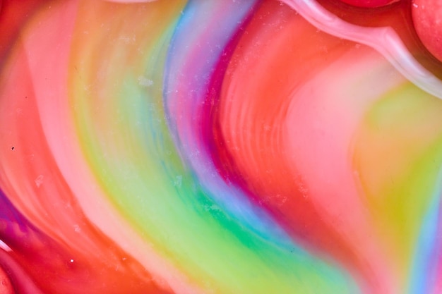 Abstract heart curved swirl of candy colors as skittles sugar mixes with water in background asset