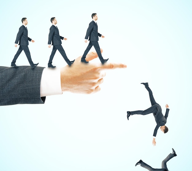 Photo abstract image of businessmen walking and falling off pointing hand on blue background risk and failure concept