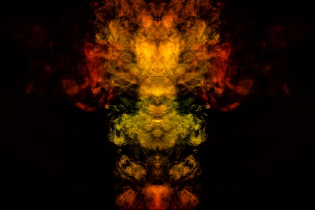 Abstract image of smoke of different green yellow orange and red colors in the form of horror in the shape of the head face and eye on a black isolated background Soul and ghost in mystical symbol