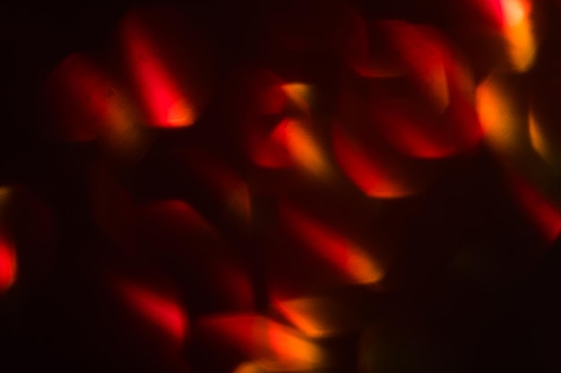 Abstract lens flare on black background red defocused bokeh lights blurred new year wallpaper decor illuminated glowing colorful circles design