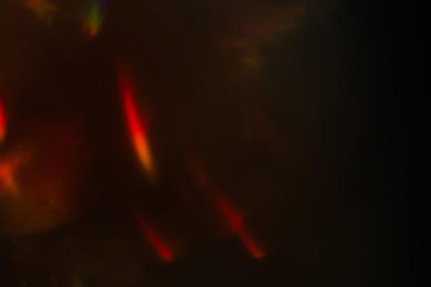 Abstract lens flare on black background red defocused lights glowing blurred color burst festive new year backdrop