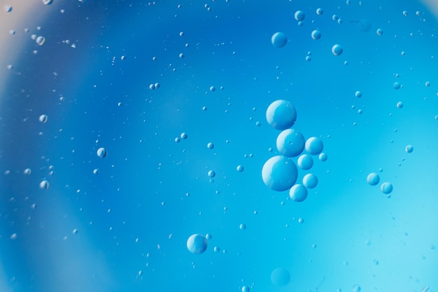 Abstract light blue background with oil circles bubbles of water close up