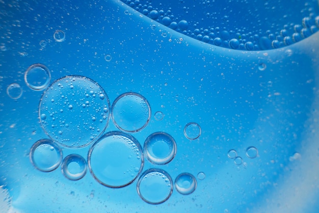 Abstract light blue background with oil circles bubbles of water close up