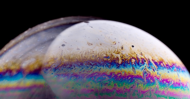 Abstract macro of soap bubble. Close up surface of soap bubble seems like planet in space. Bright creative background.
