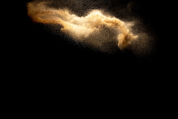 Abstract motion blurred brown color sand splash against black background.