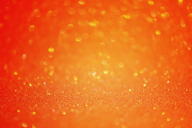 Abstract orange background. Blurred focus of glitter with radiance.