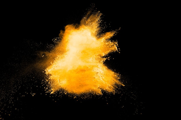 Photo abstract orange powder splattered on dark background.