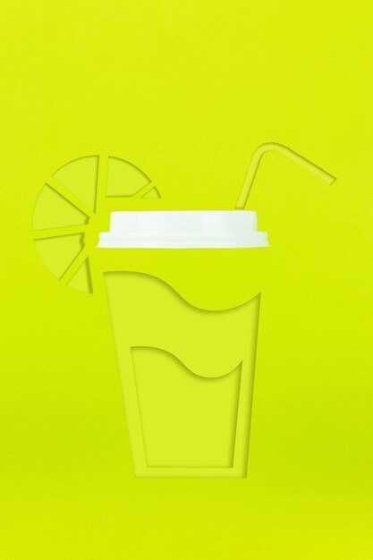 Фото Абстрактная бумажная кофейная чашка, соломинка для питья и лимон, вырезанные из бумаги в нежных зеленых тонах, с настоящей пластиковой крышкой