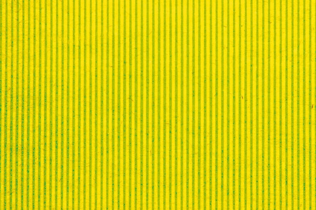 抽象的な紙の黄色の幾何学的な対称テクスチャ ストライプ表面の垂直線の背景。構造体