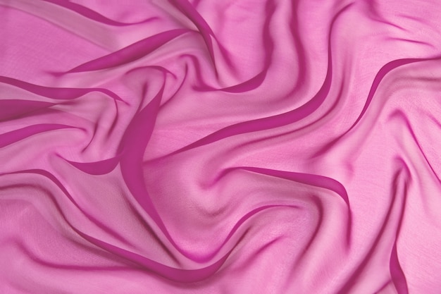 Photo abstract pink color silk chiffon fabric texture background.