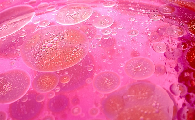 Abstract pink and purple background formed by oil drops on\
water