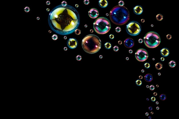 Abstract rainbow soap bubbles floating in the dark