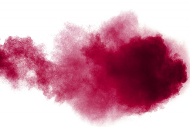 Abstract red dust splattered on white background. Red powder explosion.Freeze motion of red particles splashing.