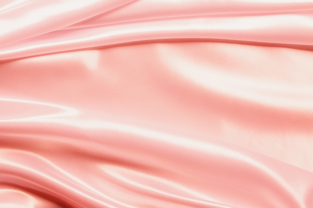 Abstract Rose gold Satin Silky Cloth for background, Fabric Textile Drape with Crease Wavy Folds.with soft waves,waving in the wind.