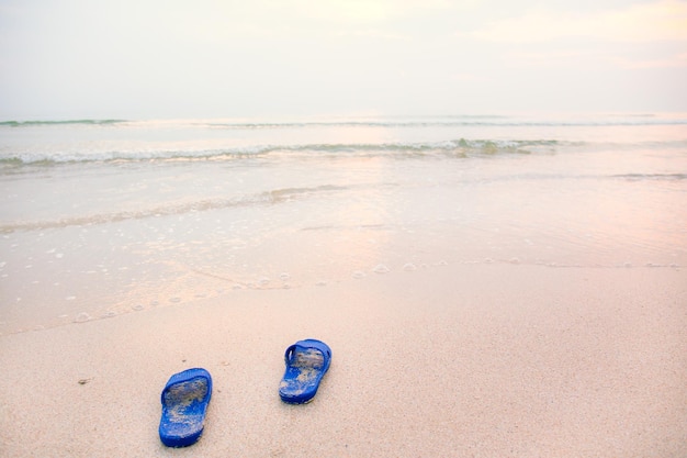 Photo abstract shoes on the beach in the morning sunlight illustration in a comfortable vacation by the sea