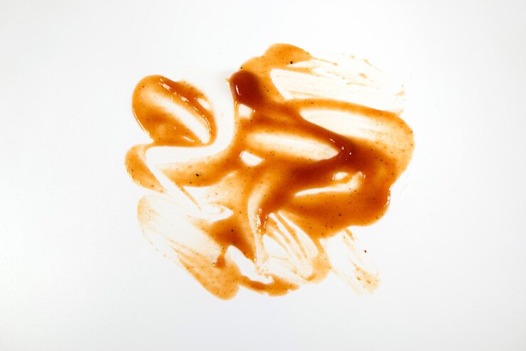 Abstract smears of red tomato sauce isolated on white as texture or background Top view