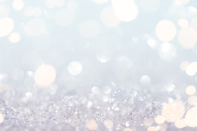 Photo abstract snow and glitter background with gold lights