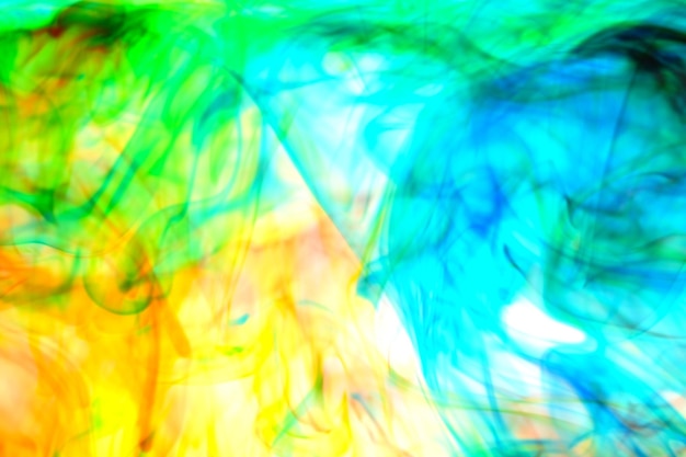 Abstract Soft Focus Green and Orange Ink flowing In Water On White background