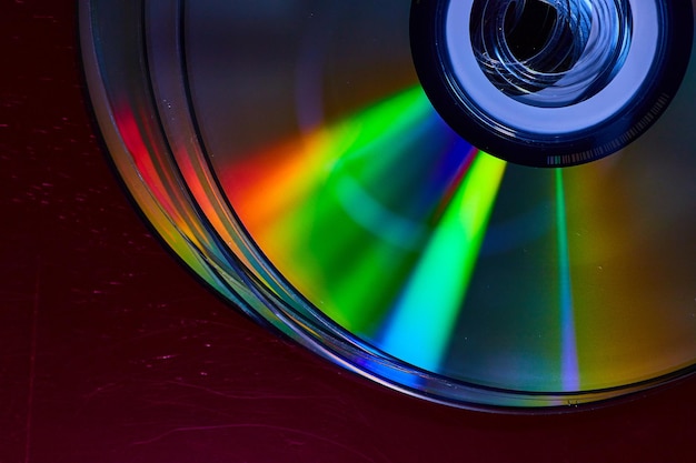 Abstract stack of four bright silvery CDs with reflective rainbow colored bursts of light on surface