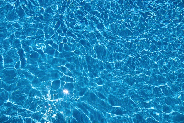スイミングプールと太陽の反射で澄んだ青い水と抽象的な夏の背景