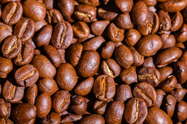 Абстрактный фон текстуры жареных кофейных зерен крупным планом, ингредиент семян черного коричневого цвета