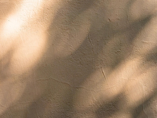 Абстрактная текстура тени на бежевой выветрившейся и потрескавшейся стене