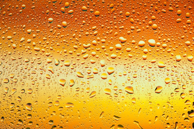 Abstract texture. Water drops on glass with orange background