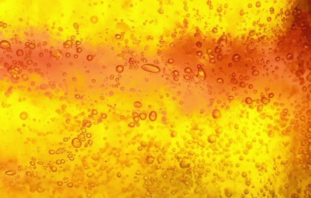 Photo abstract textured gel background yellow and orange liquid with bubbles