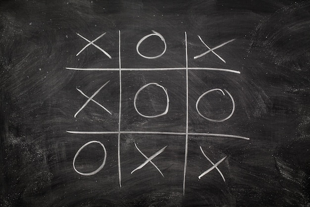 Photo abstract tic tac toe game competition xo win challecge concept on black board