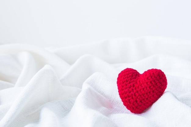 Абстрактный день святого валентина Красное сердце Вязание на белой ткани льняной текстуры для графического дизайна свадьбы или добавить текстовое сообщение Концепция любви