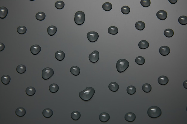 Photo abstract water drops on grey background macro bubbles close up cosmetic moisturizing liquid drops flat lay pattern