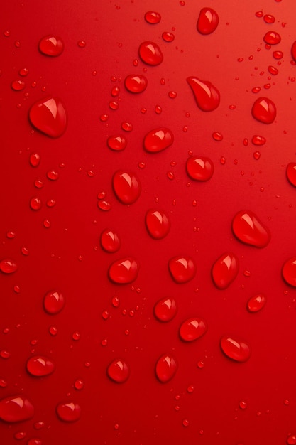 Abstract water drops on red background macro bubbles close up cosmetic liquid drops flat lay pattern
