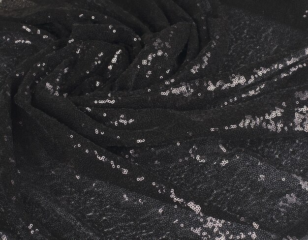 Abstract wavy folds of black fabric with sequins