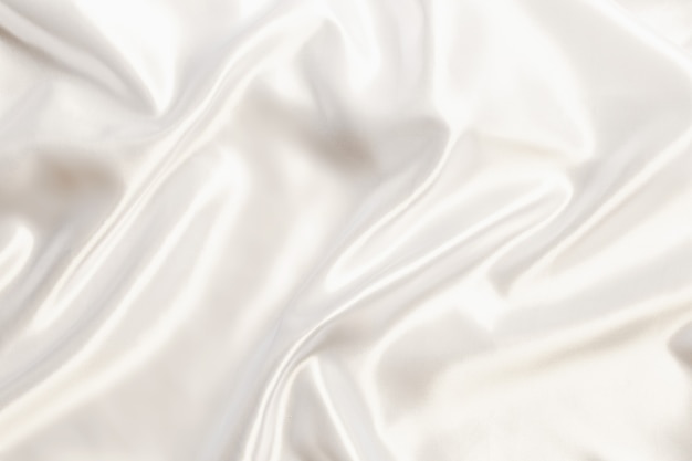 Panno setoso di raso bianco astratto per lo sfondo, tessuto tessile drappo con pieghe ondulate piega.con onde morbide, ondeggianti nel vento.