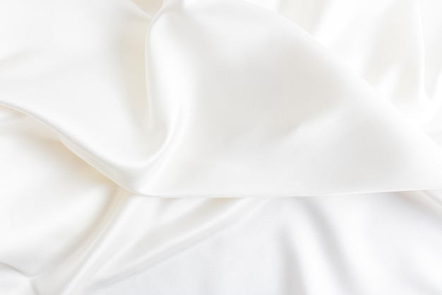 Abstract White Satin Silky Cloth for background Fabric Textile Drape with Crease Wavy Foldswith soft waveswedding in the wind