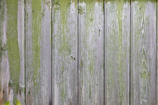 Abstract with wooden texture and peeling wiped green paint.