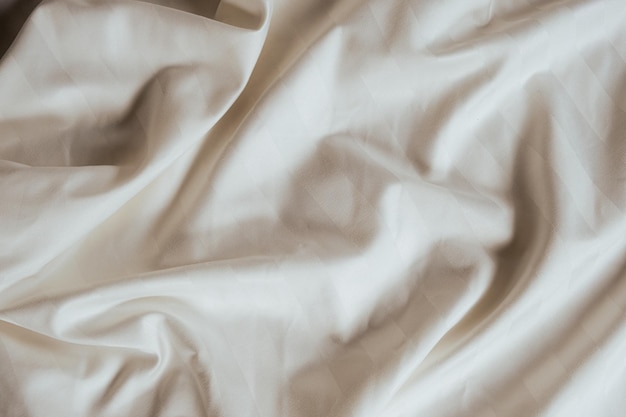 Abstracte beige stof achtergrond satijn streep textuur golvende plooien van elegante dure stof
