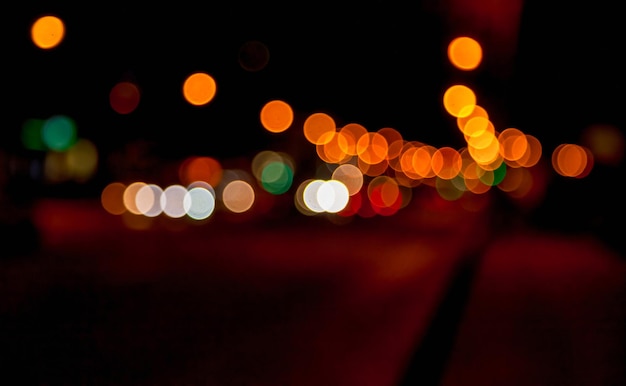 Abstracte bokehachtergrond van nachtstraat met auto en straatlantaarns