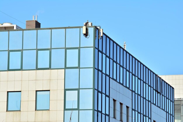 Foto abstracte close-up van de glazen gevel van een modern gebouw bedekt met reflecterend glas.