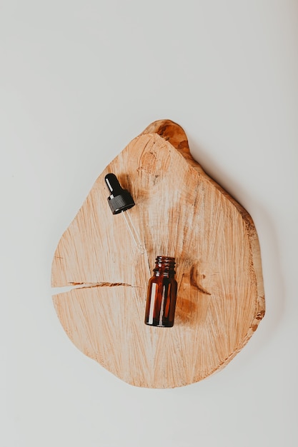 Foto abstracte cosmetische laboratoriumflessen van donker amber glas op een houten podium natuurlijke cosmetische platte st...