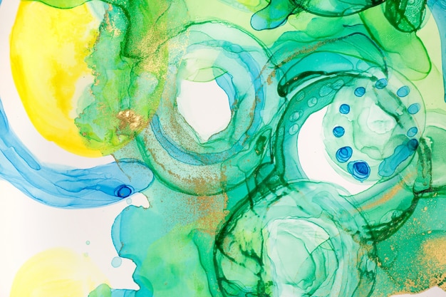 Abstracte inkt blauw groene en gele aquarel inkt druppels achtergrond alcohol inkt