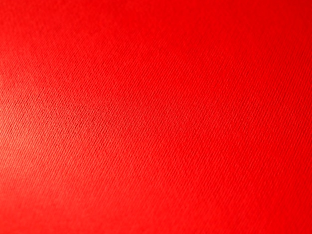 Abstracte rode achtergrond met textuur Close-up van papier oppervlak met licht en kleurverloop Zijverlichting Heldere karmozijnrode achtergrond