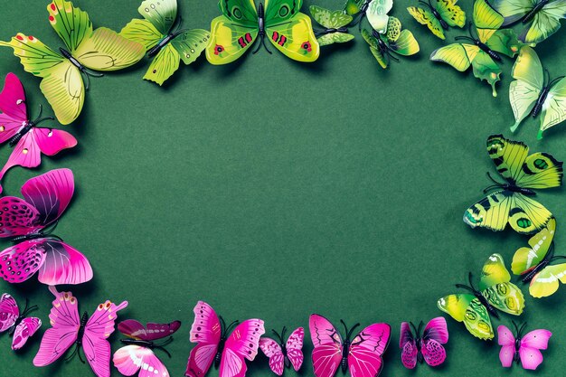 Abstracte smaragdgroene achtergrondkleur met kunstmatige groene en paarse vlinders Bespotten met kopieerruimte