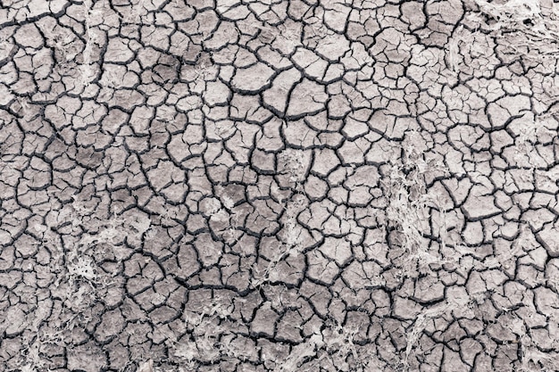 Abstracte top-down weergave van gebarsten droge modder klei met diepe gekartelde scheuren