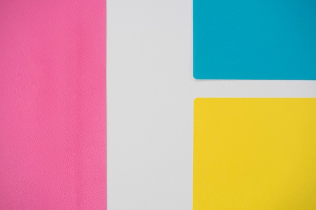 Abstracte witte achtergrond voor ontwerp met roze, blauw en geel papier. Uitzicht van boven.