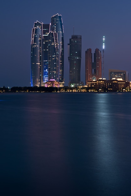 Abu Dhabi buildings skyline from the sea at night